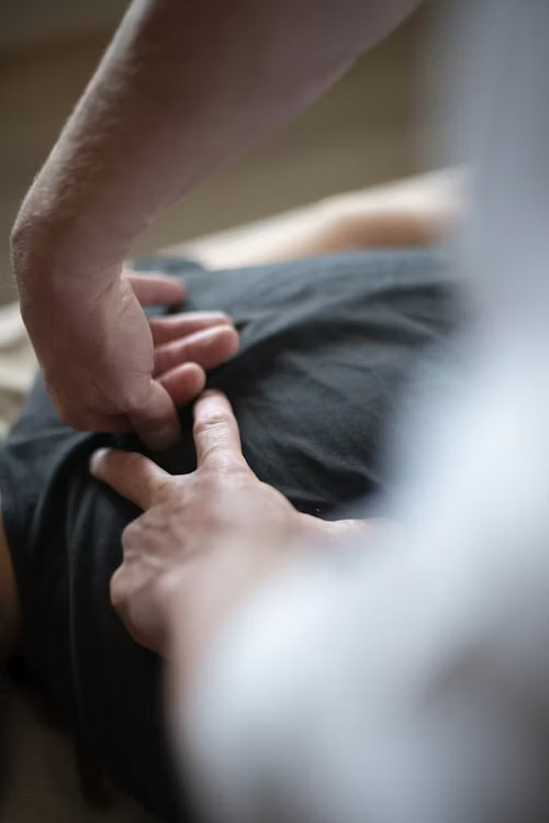 Close-up of Akasha Osteopathy massage with therapist’s hands applying holistic pressure to a client’s back.